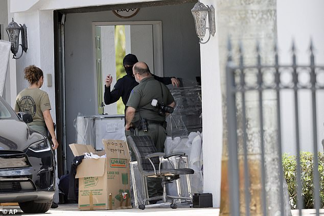 Broward Sheriff's Office personnel move items in the garage of Sean Kingston's Southwest Ranches, Florida, home