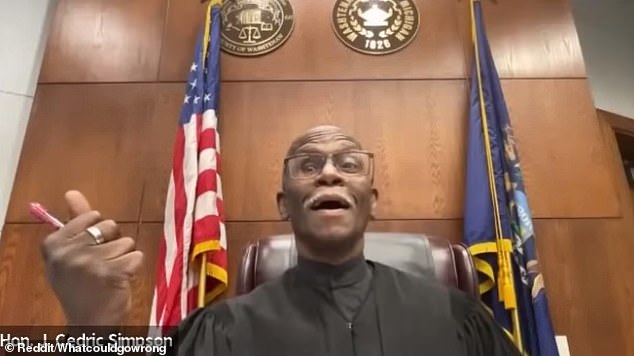 Ann Arbor District Judge Cedric Simpson is seen in the video reacting with disbelief as Harris dials in, his seat belt visible across his torso and his car clearly in motion