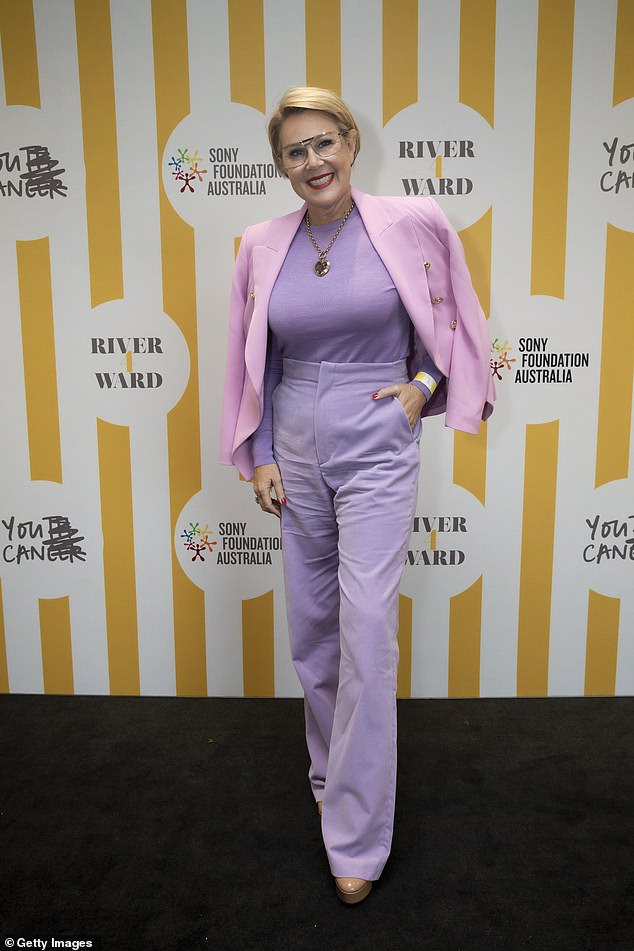 Julia Morris dressed to impress in purple pants, a matching colored shirt and a pink blazer