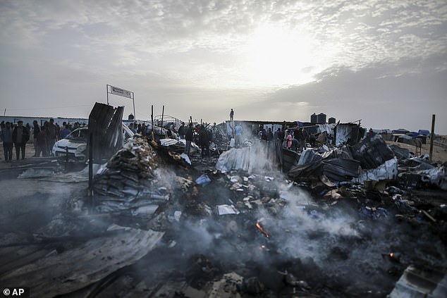 Palestinians look at the destruction after an Israeli attack that left displaced people in Rafah in the Gaza Strip