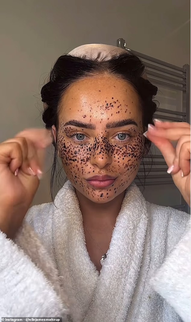 Elle produces a tube of dark brown henna and begins drawing clusters of dots across the bridge of her nose, cheeks, eyelids, forehead and chin.