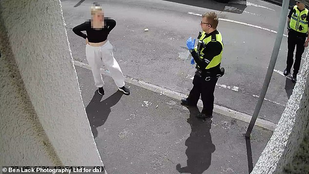 Footage from later in the afternoon shows officers arriving to collect the dog and then remaining on the scene for almost four hours.  The owner is seen here dressed in a black top and pleads with the officers: 'You are hurting him.  Let me put the muzzle on him.”