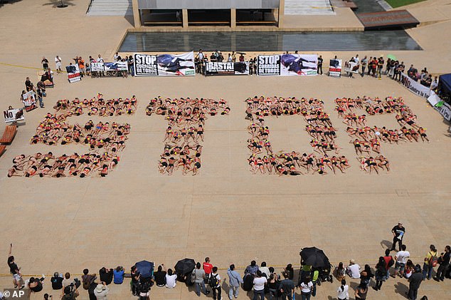 Animal rights activists form the word 'Stop' with their bodies during a protest against bullfighting in Medellín, Colombia in February 2012