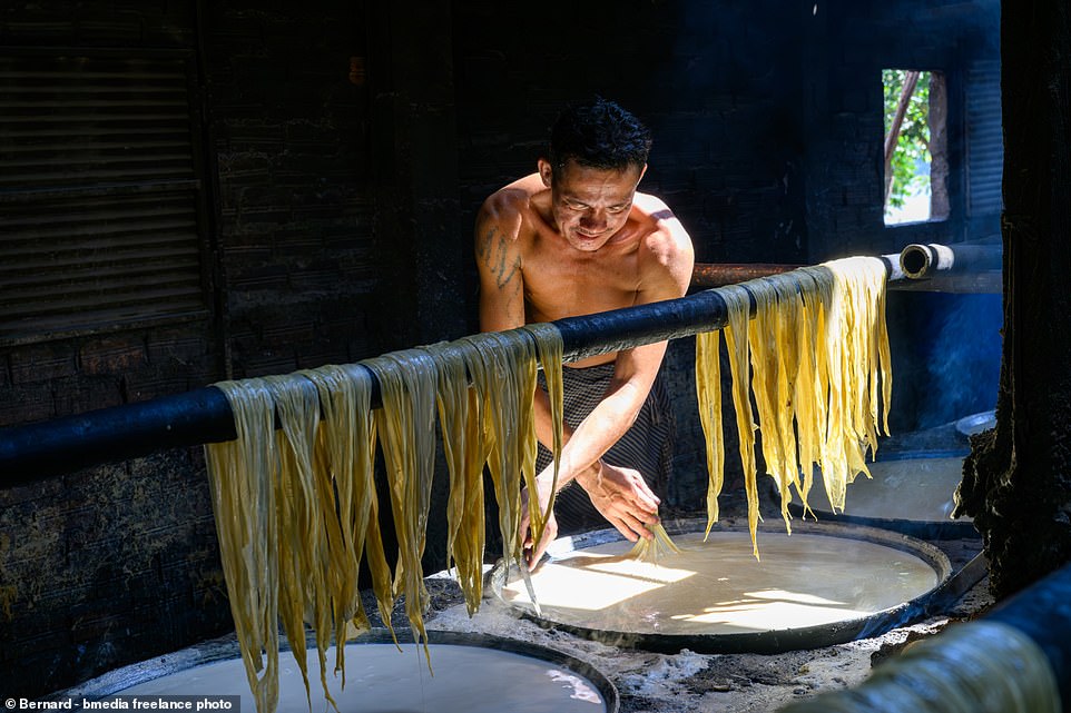 KOH DACH ISLAND, CAMBODIA: Bean curd peels are a popular food item in China, Japan and Korea.  You see how this worker makes them by hand