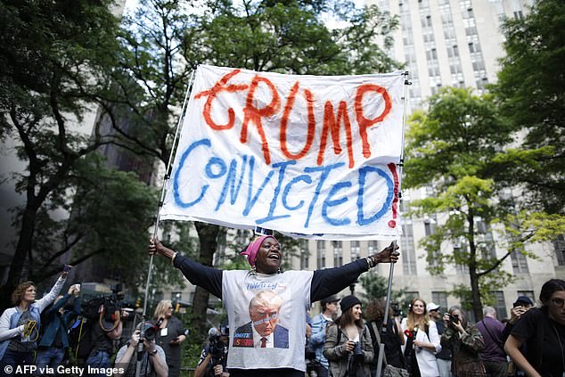 A woman holds up a banner outside the courthouse celebrating Trump's conviction