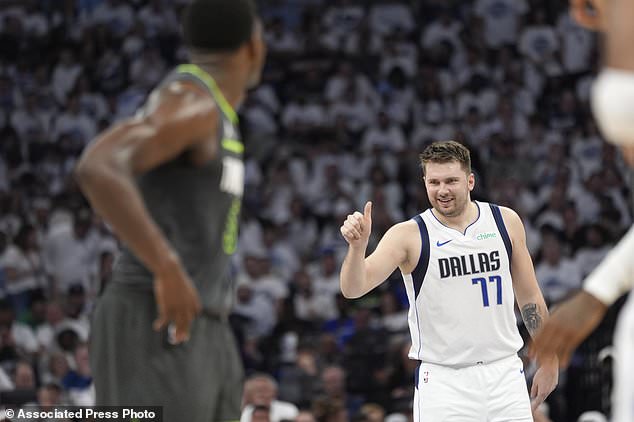 Dallas guard Luka Doncic (77) celebrates his score as Minnesota Timberwolves guard Anthony Edwards, left, looks on during the first half of Game 5 of the Western Conference Finals