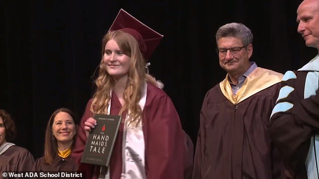 Wearing a maroon cap and gown, Jenkins walked across the stage shaking everyone's hands in front of Bub, grabbing a copy of the book as she approached him.