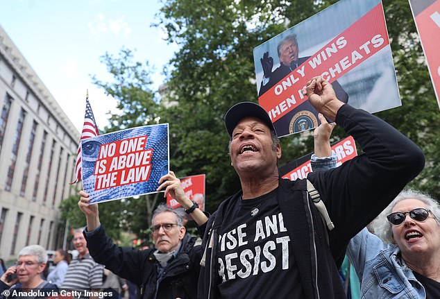 Anti-Trump protesters gather with banners after the verdict in Trump's hush money trial