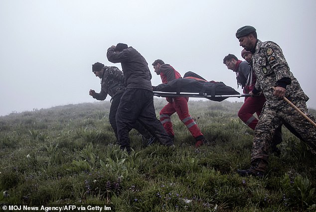 Rescuers recover bodies at the crash site of a helicopter carrying Iran's president, its foreign minister and others in a fog-covered mountainous area of ​​Varzaghan in northwestern Iran on May 20, 2024