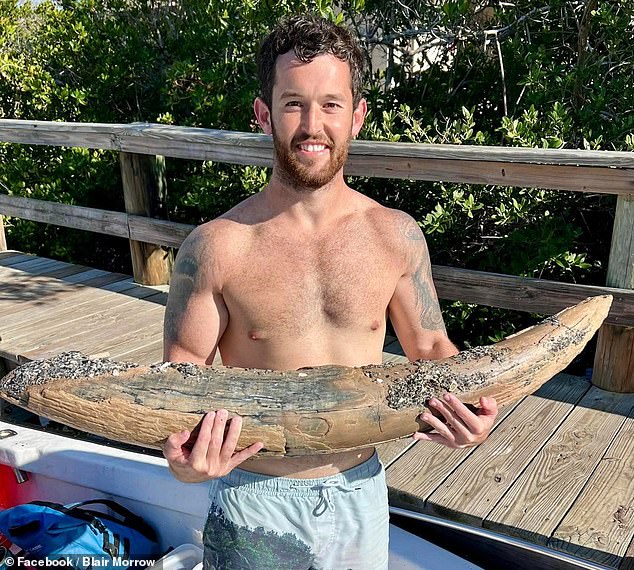 Alex Lundberg (pictured with the mastodon tusk) said he hoped he could keep the fossil and was surprised that it remained intact when he pulled it out of the water