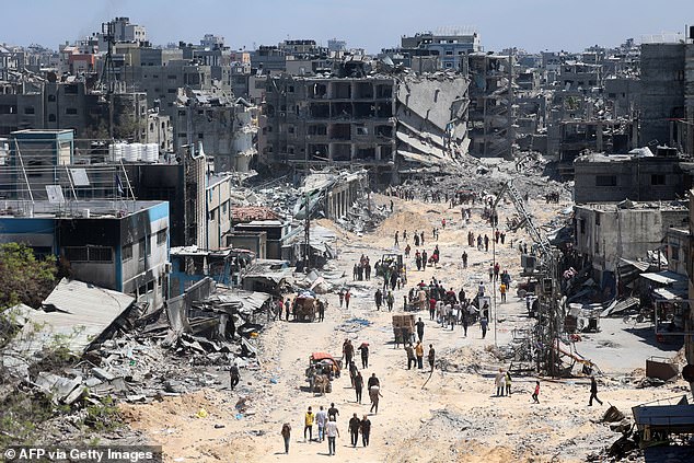 Palestinians carry some salvaged belongings with them as they leave the Jabalia refugee camp