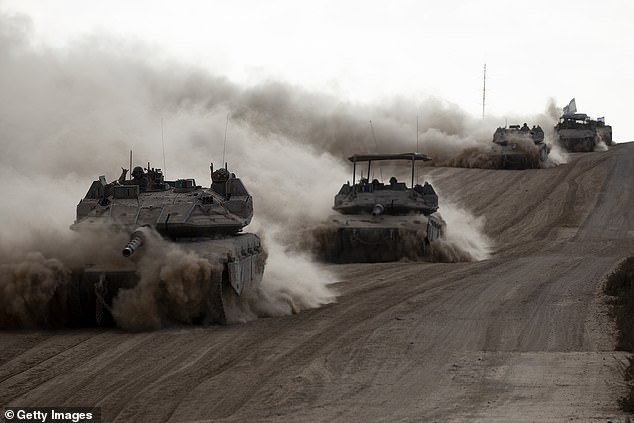 Israeli tanks drive along the border with the Gaza Strip on May 29