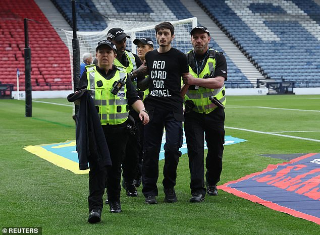 The protester – whose T-shirt read 'RED CARD FOR ISRAEL' – was untied and led away