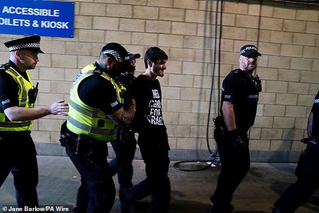 Several police officers led the man away and into the stadium after arresting him