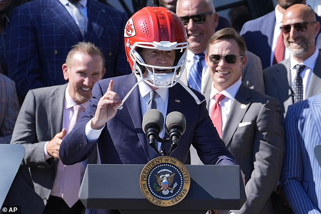 President Joe Biden was presented with a Kansas City Chiefs helmet by the Super Bowl winning team and briefly pressed it to his head.  “Thank you very much,” he said