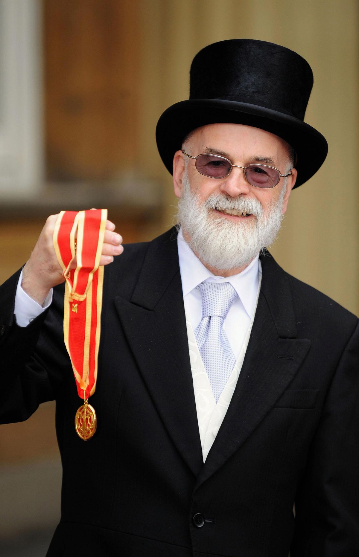 Sir Terry Pratchett displays his knighthood award outside Buckingham Palace.