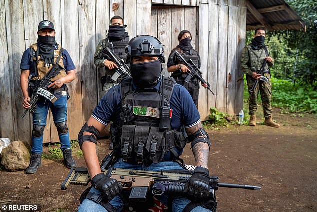 Members of the Jalisco New Generation Cartel (CJNG) pose for a photo at an undisclosed location in the state of Michoacan, Mexico