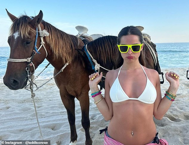 Addison Rae showed off her curves in a white bikini top as she posed with horses on a beach in Mexico