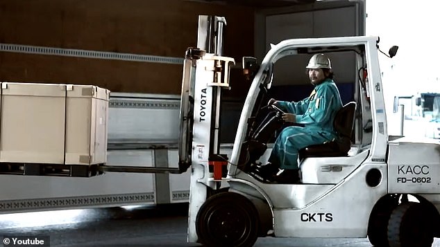 A worker carefully transports cargo at Kansai International Airport in Japan