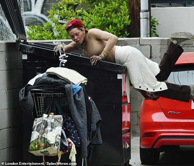 Homeless former model Loni Willison is pictured in a dumpster diving headfirst for beauty products while donning a form-fitting nude shirt and lugging around a shopping cart