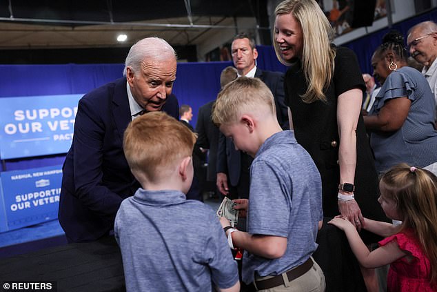 President Joe Biden gives ice money to Jack Brown, 7, and Carter Brown, 5, as he meets them and their veteran mother Megan Brown, with her daughter Madeline Brown, 3