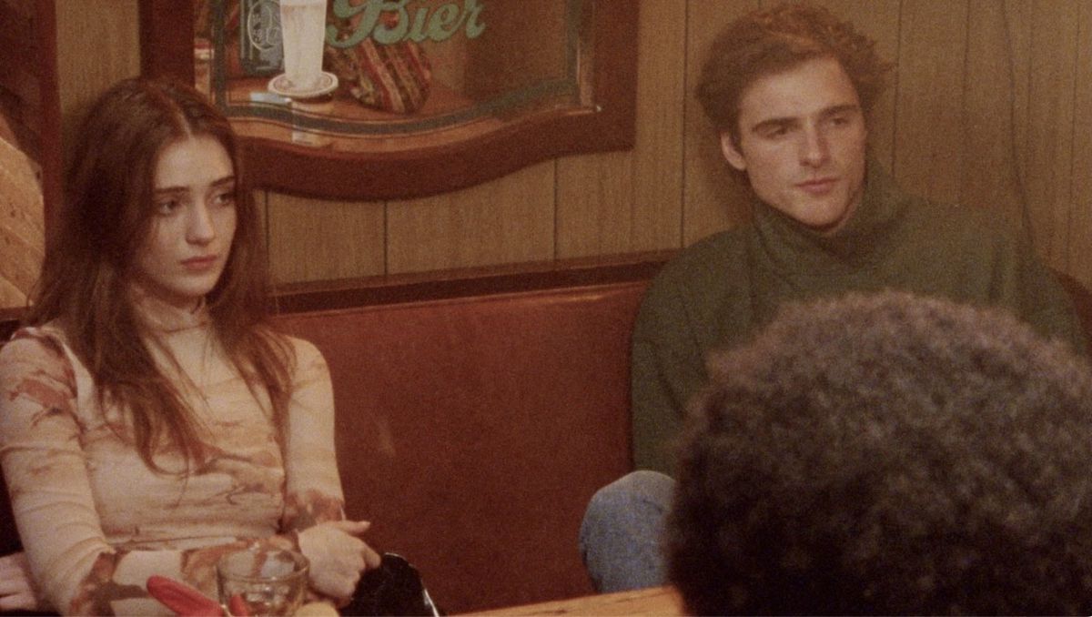 A young woman and a man sit in a restaurant booth at The Sweet East.