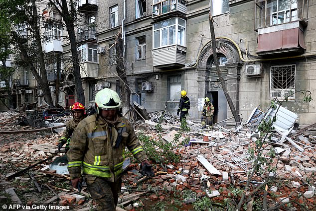 Ukrainian rescue workers work in the courtyard of a residential building damaged as a result of a rocket attack in Dnipro