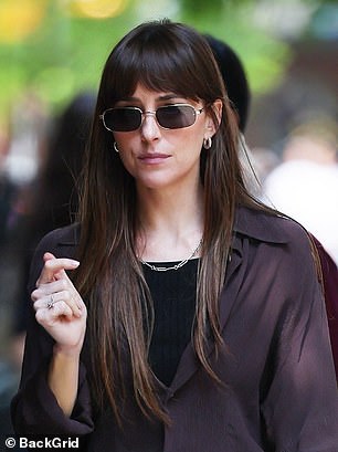 Dakota Johnson wore rectangular sunglasses with dark lenses and thin silver frames