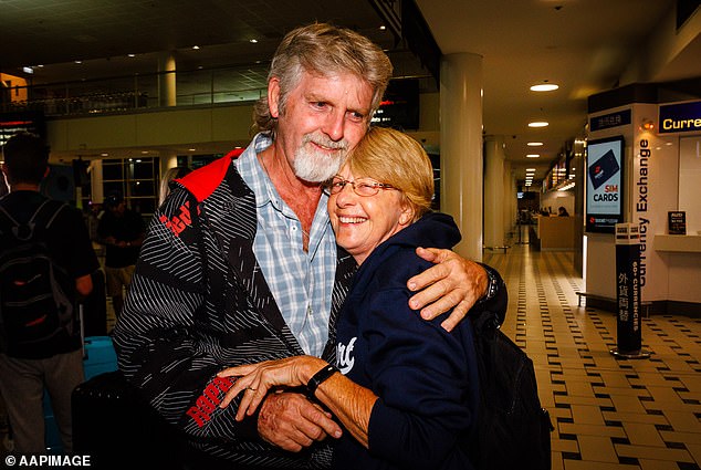 Rob Slade (pictured left) greets his partner Vicki Murray (right) after arriving from New Caledonia