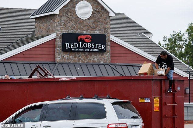 A man collects items from a dumpster in front of a closed Red Lobster restaurant with all its contents up for auction in San Diego, California, U.S., May 15, 2024