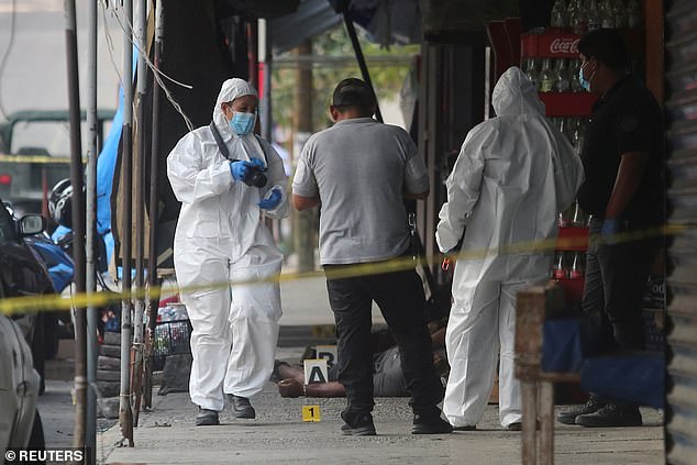 Forensic technicians work at a crime scene where unknown assailants attacked a store, killing five people, including one woman, and injuring one man on Thursday.
