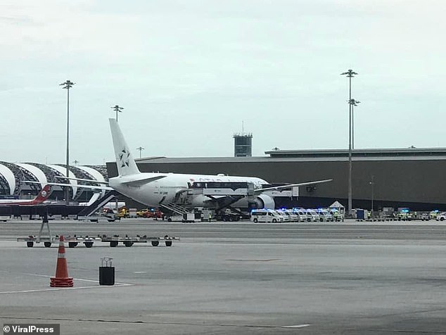 A passenger was reportedly killed and 30 others injured on a flight from London to Singapore this afternoon, forcing an emergency landing in Thailand.  Pictured: Ambulances are seen today on the tarmac of Bangkok's Suvarnabhumi International Airport
