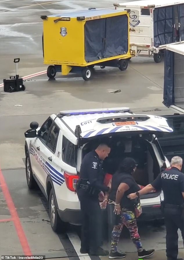 She was eventually escorted off the plane by police officers in handcuffs, as angry passengers watched from the airport after they disembarked.