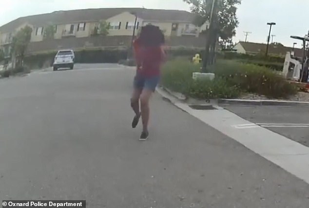 The officer backs away until the girl starts running, prompting him to shoot her three times
