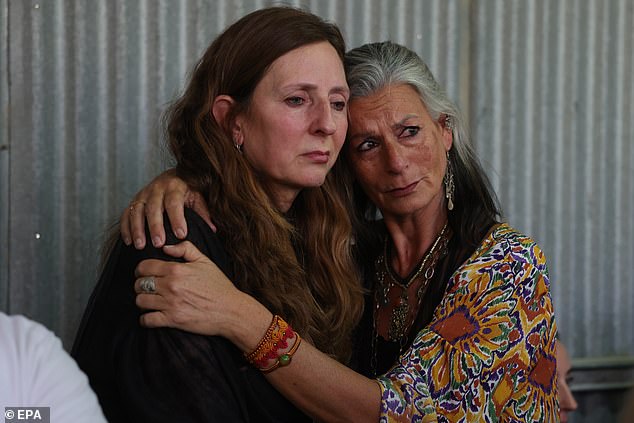 Shanni Louk's mother (left) is comforted by a friend during her daughter's funeral