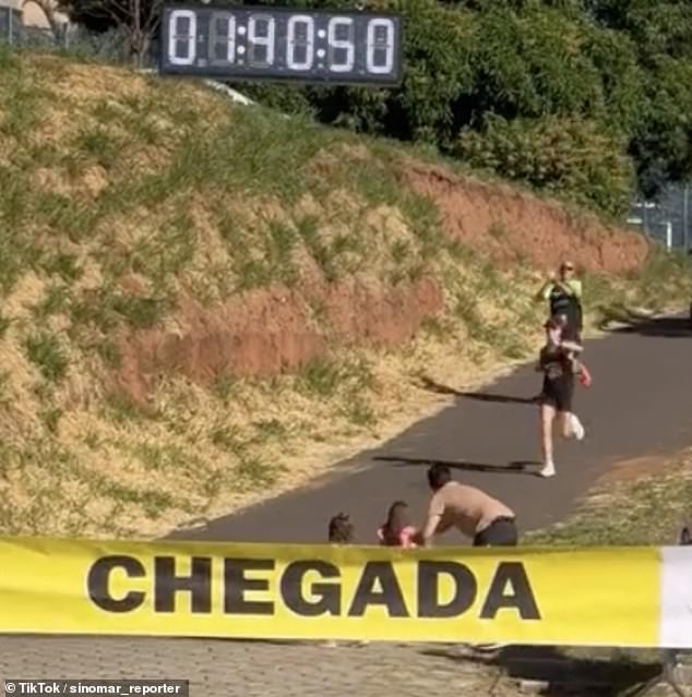 Pictured: A participant in Presidente Prudente's recent half marathon approaches the finish line when two young girls run ahead of her