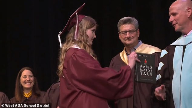 Annabelle Jenkins presented West Ada Superintendent Derek Bub with a graphic novel adaptation of “The Handmaid's Tale” during the Idaho Fine Arts Academy commencement on May 23