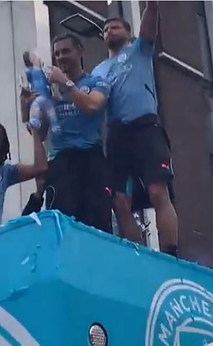 Jack Grealish (left) and Rodri (right) stand on top of the Man City bus for their title parade