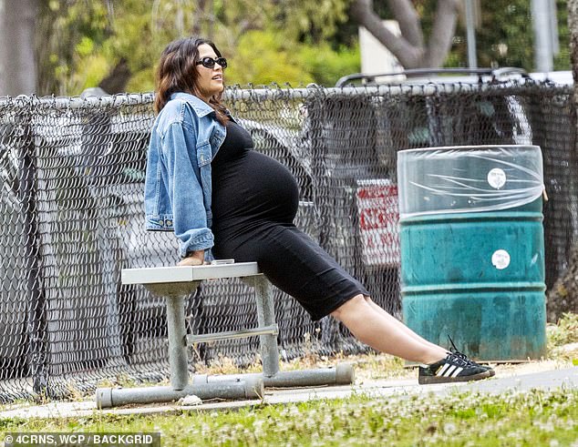 The mother-to-be wore a black dress that concealed her growing baby bump, with a blue denim jacket over the dress