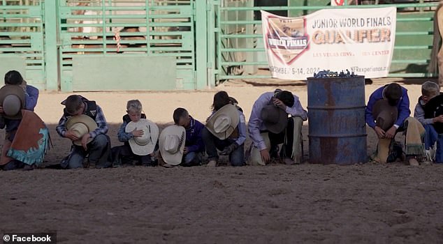 The young cowboys are depicted holding their hats and kneeling on the ground in prayer for Levi