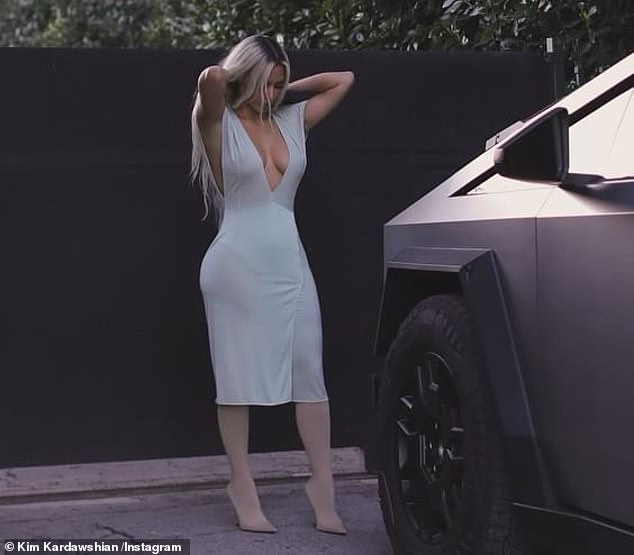 Kim Kardashian, 43, showed off her curves in a figure-hugging faux wrap dress on social media on Sunday in a series of photos with her Cybertruck