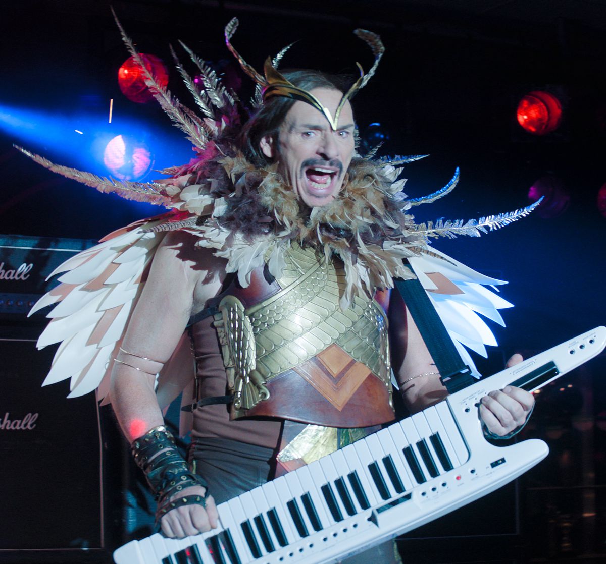 Julian Barrett plays a keytar while dressed as an owl in Knuckles