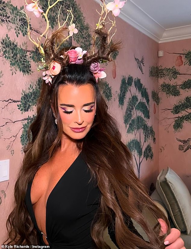 The Halloween Ends actress sizzled in a plunging black dress, which she accessorized with floral-adorned antlers