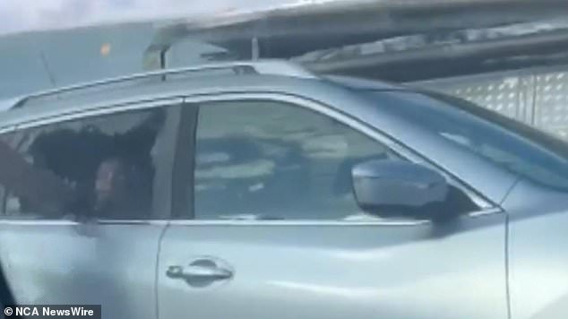 Shocking footage shows a man smashing through a car window, injuring a mother who had a child in the back in a horrific road rage incident.  Image: 9News