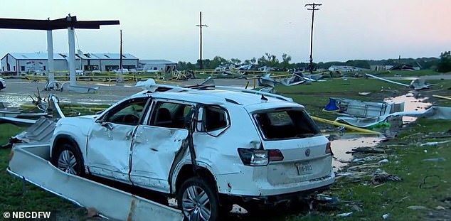 A car at the gas station is severely damaged by the twister