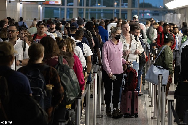 Travelers wait in line for the Transportation Security Administration (TSA) security checkpoint at Ronald Reagan Washington National Airport in Arlington, Virginia, U.S., May 24, 2024