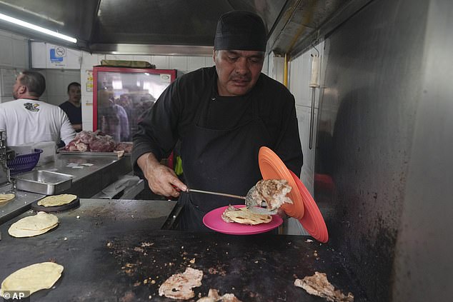 Newly minted Michelin-starred chef Arturo Rivera Martínez prepares an order of tacos at Tacos El Califa de León taco stand in Mexico City, Wednesday, May 15, 2024