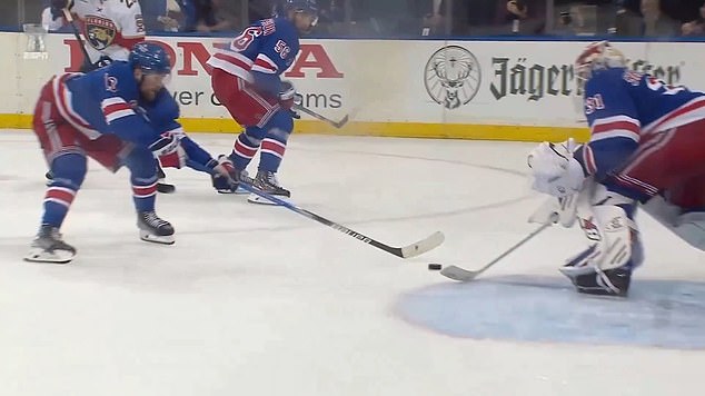 Alexis Lafrenière is seen tapping an own goal through Rangers netminder Igor Shesterkin