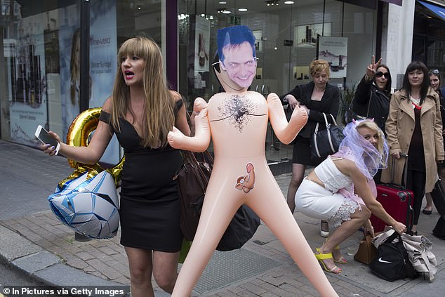 A group of stag and hen parties are pictured posing with an inflatable sex doll, an item banned in the town of Platka d'Aro on the Costa Brava.