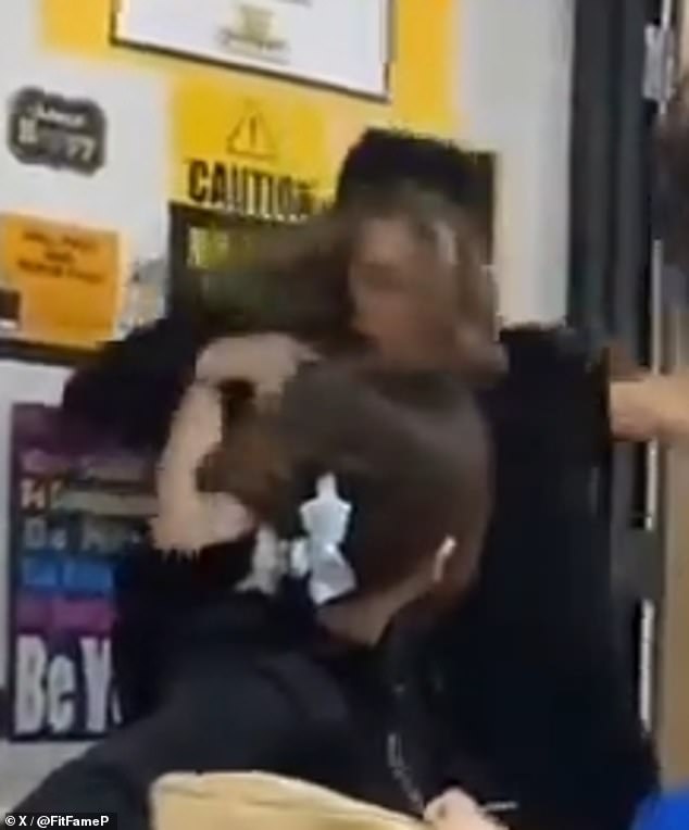 The disturbing footage shows the female teacher frantically trying to get between the two students.  Suddenly, one of the boys aggressively grabs the teacher and throws her to the ground, while classmates scream in shock